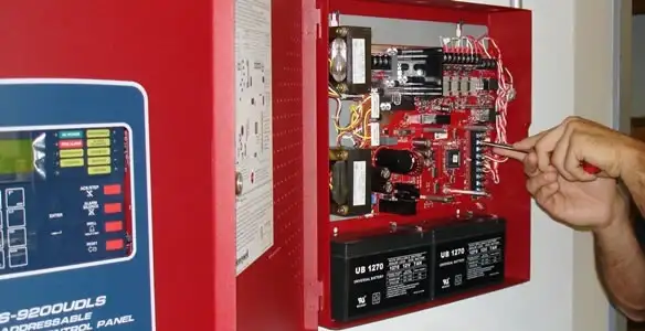 fire alarm installation service showing technician configuring fire alarm control panel in Detroit, MI