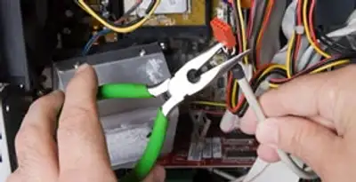 Licensed electrical contractor performing electrical repair with tools in Dearborn, MI