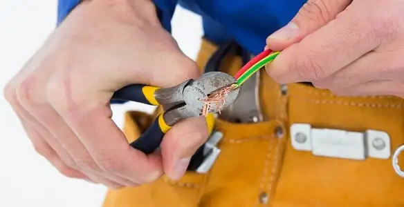 licensed electrician securing electrical wiring with professional tools during service work in Detroit, MI